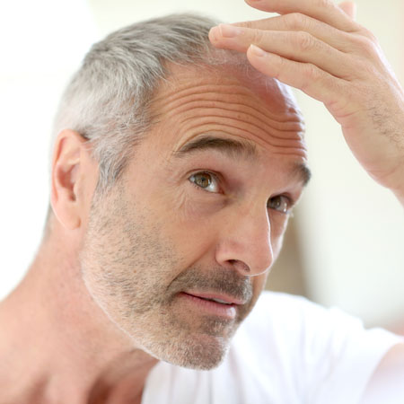 Man looking at his receeding hair in the mirror